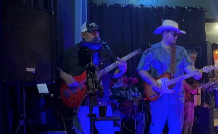 The four-piece across the stage at Pflutto's, bass and two guitars out front with the drummer behind.